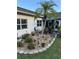 Landscaped backyard with patio, table, umbrella, landscaping rocks, and palm trees at 5982 Crane Dr, Lakeland, FL 33809