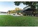 Grassy backyard with swimming pool, screened-in patio, trees, and landscaping at 1215 Cypress E Pt, Winter Haven, FL 33884