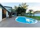 Backyard swimming pool with concrete deck, white vinyl fence, and mature landscaping at 1215 Cypress E Pt, Winter Haven, FL 33884