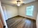 Cozy bedroom featuring wood floors, ceiling fan, and a sunlit window with peaceful view at 1271 Groveland Ln, Lakeland, FL 33811