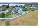 Aerial view of a fenced backyard including play structure with lake views in the distance at 1935 Austin Ter, Winter Haven, FL 33884