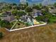 Expansive aerial view of the home with a basketball court, playground, and fenced yard in a well-kept neighborhood at 1935 Austin Ter, Winter Haven, FL 33884
