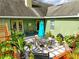 Back patio featuring an outdoor dining area, potted plants, and easy access to the home's interior at 1935 Austin Ter, Winter Haven, FL 33884