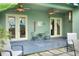A quaint covered patio offers seating, two ceiling fans, and tranquil views of the property and landscaping at 1935 Austin Ter, Winter Haven, FL 33884
