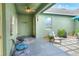 Covered back patio with seating, a ceiling fan, and view of the exterior of the property and landscaping at 1935 Austin Ter, Winter Haven, FL 33884