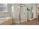 Spacious bathroom featuring a soaking tub, tiled shower with a seat, and a mirror above the vanity at 1935 Austin Ter, Winter Haven, FL 33884
