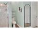 Bathroom showcasing a tiled shower, a toilet, and a decorative, arched mirror at 1935 Austin Ter, Winter Haven, FL 33884