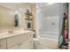 A well-lit bathroom features a vanity with storage and a tiled shower-tub combination with a shower curtain at 1935 Austin Ter, Winter Haven, FL 33884