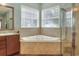 Bathroom showcasing a corner soaking tub beneath bright windows and a glass enclosed shower at 1935 Austin Ter, Winter Haven, FL 33884