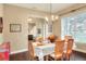 Bright dining room with hardwood floors, natural light, and a decorative chandelier overlooking a formal dining set at 1935 Austin Ter, Winter Haven, FL 33884