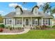 Charming two-story home with black shutters, a welcoming front porch, and nicely landscaped front yard at 1935 Austin Ter, Winter Haven, FL 33884