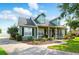 Two-story home with black shutters and dormer windows, featuring a welcoming front porch and a spacious driveway at 1935 Austin Ter, Winter Haven, FL 33884