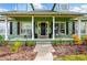 Inviting home featuring a covered front porch with decorative columns and well-manicured landscaping at 1935 Austin Ter, Winter Haven, FL 33884