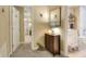 Hallway with neutral carpet leading to an office and a bathroom with a vanity and bath with white subway tiles at 1935 Austin Ter, Winter Haven, FL 33884