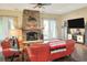 Cozy living room with brick fireplace, entertainment center, and wood floors at 1935 Austin Ter, Winter Haven, FL 33884