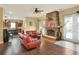 Open living room with wood floors, brick fireplace, and kitchen in the background at 1935 Austin Ter, Winter Haven, FL 33884