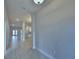Bright hallway featuring tile flooring leading to the kitchen and living areas at 4688 Grandview Glen Dr, Auburndale, FL 33823