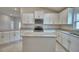Bright kitchen features white cabinetry, granite countertops, stainless steel appliances and an island at 4688 Grandview Glen Dr, Auburndale, FL 33823