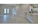 Open living room featuring neutral paint, wood-look tile floors, and access to kitchen and fenced backyard at 4688 Grandview Glen Dr, Auburndale, FL 33823