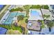 Aerial view showcases a tennis and basketball court, pool, and playground, surrounded by lush landscaping at 4694 Grandview Glen Dr, Auburndale, FL 33823