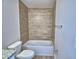 Bathroom showcasing a tub with tiled wall, bronze fixtures, and toilet at 4694 Grandview Glen Dr, Auburndale, FL 33823