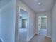 Hallway showcasing open doorways to a bedroom with closet and another room at 4694 Grandview Glen Dr, Auburndale, FL 33823