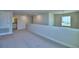 Spacious loft area with neutral carpet, lighting fixtures, and half wall with easy bathroom access at 4694 Grandview Glen Dr, Auburndale, FL 33823