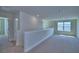 Open loft area with carpet flooring, natural light, and neutral color palette at 4694 Grandview Glen Dr, Auburndale, FL 33823