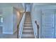Carpeted staircase with white railing and natural wood accents at 4694 Grandview Glen Dr, Auburndale, FL 33823