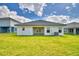 Spacious backyard featuring a patio, lush grass, and a modern house at 4700 Grandview Glen Dr, Auburndale, FL 33823
