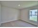 Cozy bedroom features neutral carpet, a window with backyard views, neutral paint, and base trim at 4700 Grandview Glen Dr, Auburndale, FL 33823
