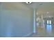 Bright hallway with neutral walls and tile flooring leads to the kitchen and dining area at 4700 Grandview Glen Dr, Auburndale, FL 33823