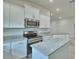 Modern kitchen with granite countertops, stainless steel appliances, and white cabinets at 4700 Grandview Glen Dr, Auburndale, FL 33823