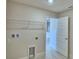 Bright laundry room features a wire rack and hookups for washer and dryer; doorway to a hall is visible at 4700 Grandview Glen Dr, Auburndale, FL 33823
