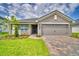 Charming single-story home featuring a paved driveway, manicured lawn, and covered porch entry at 4706 Grandview Glen Dr, Auburndale, FL 33823