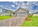 Beautiful home exterior with a manicured lawn, brick driveway, and inviting entrance at 4706 Grandview Glen Dr, Auburndale, FL 33823
