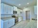 Modern kitchen featuring white cabinets, stainless steel appliances, and granite countertops at 4706 Grandview Glen Dr, Auburndale, FL 33823