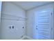 Functional laundry room with a storage shelf and a white door at 4706 Grandview Glen Dr, Auburndale, FL 33823