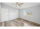 Empty bedroom showcasing wood-look floors, a ceiling fan, fresh paint, and two closets at 5225 Golden Gate Blvd, Polk City, FL 33868