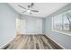 A bright bedroom with a ceiling fan, hardwood floors, and a sunlit window at 5225 Golden Gate Blvd, Polk City, FL 33868