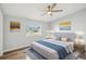 Well-lit bedroom with a ceiling fan, wood-look flooring, a plush bed, and tasteful wall art at 5225 Golden Gate Blvd, Polk City, FL 33868
