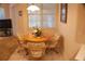 Cozy dining area with a round table, upholstered chairs, and a window with blinds at 108 Lake Region N Blvd, Winter Haven, FL 33881