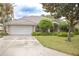 Inviting single-story home with a well-maintained lawn, mature trees, and two-car garage at 108 Lake Region N Blvd, Winter Haven, FL 33881