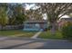 Charming, light-blue single story home features a covered front porch and a well-maintained lawn at 506 N Wales Dr, Lake Wales, FL 33853