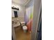 Compact bathroom features a sink, toilet, and shower with a colorful curtain at 3203 Decatur Ave, Lakeland, FL 33805