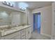 Bathroom featuring a double vanity, framed mirror, tiled floors, and bright lighting at 5126 Villa Crest Way, Auburndale, FL 33823