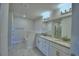 Bathroom with double vanity sinks with granite countertop, a large mirror, and modern fixtures at 5126 Villa Crest Way, Auburndale, FL 33823