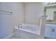 Bathroom with a clean white bathtub, with gold faucet fixtures, and granite countertop on vanity at 5126 Villa Crest Way, Auburndale, FL 33823