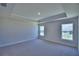 Spacious bedroom with a tray ceiling, neutral carpet, and natural light from two windows at 5126 Villa Crest Way, Auburndale, FL 33823