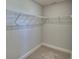 Interior view of a walk-in closet with wire shelving and carpet flooring for storage at 5126 Villa Crest Way, Auburndale, FL 33823